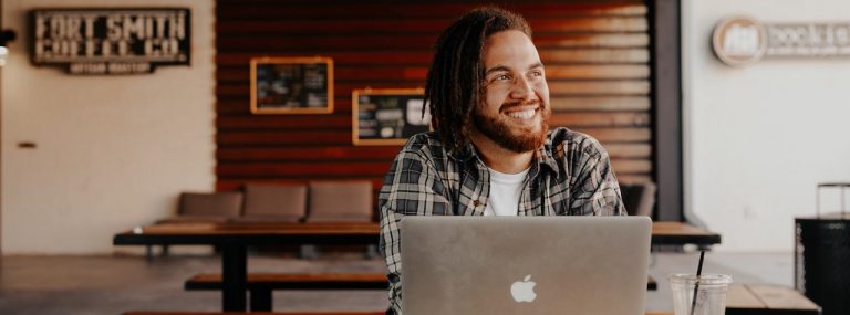 Man smiling by laptop