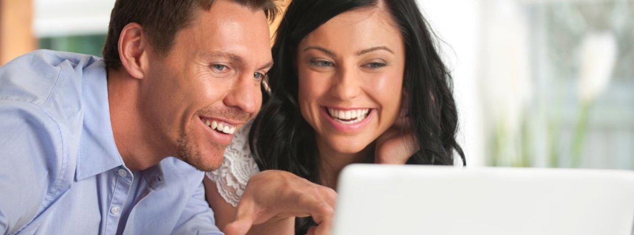 Couple with laptop smiling