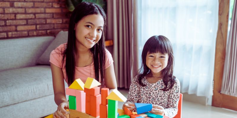 Teen helping younger kid