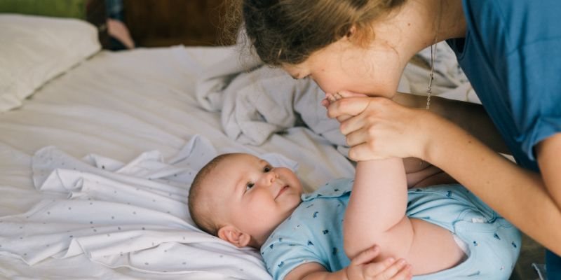 Mother kissing babies foot